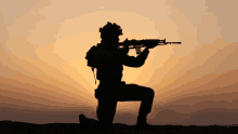 a silhouette of a man kneeling down with a gun