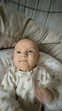 a baby is laying on a floral blanket and making a funny face