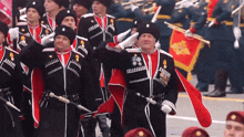 a group of men in military uniforms salute in front of a flag that says ' russia ' on it