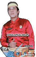 a man wearing a red shirt with the words assalamualaikum on it