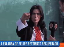 a woman in a red shirt holds a microphone in front of a sign that says la palabra de felipe