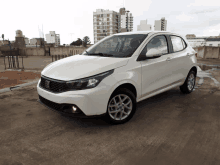 a white car is parked on a concrete surface