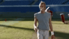 a man is walking on a tennis court with a tennis racket .