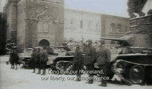 a black and white photo of soldiers standing in front of a building with the caption long live our homeland our liberty our independence