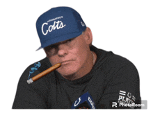 a man wearing a hat that says indianapolis colts is smoking a cigar