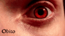 a close up of a person 's red eye with the word obito written below it