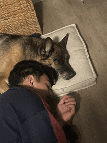 a man and a dog are laying on a pillow