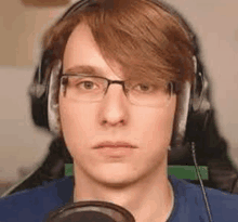 a man wearing glasses and headphones is looking at the camera .