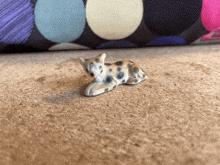 a small figurine of a dalmatian laying down