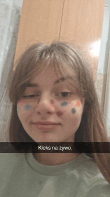 a girl with polka dots painted on her face and a caption that says " kleks na zywo "