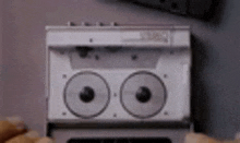 a close up of a person holding a cassette tape player with two tapes in it .