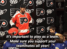 a hockey player stands in front of a sign that says it 's important to play as a team ..