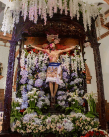 a statue of jesus on the cross is surrounded by flowers and a sign that says " el cristo "