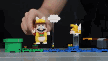 a person is playing with a set of lego mario figures .