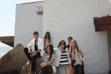 a group of people posing for a picture in front of a white wall