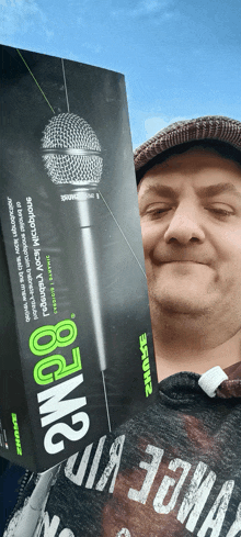 a man is holding a shure microphone in front of a box