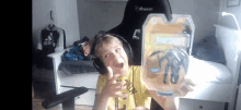 a boy wearing headphones is holding a toy that says fortnite on it