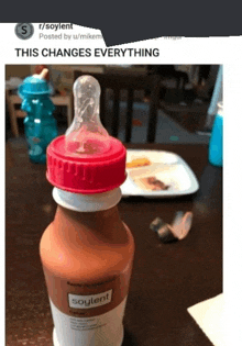 a bottle of soylent sits on a table next to a plate