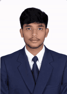 a young man in a suit and tie poses for a photo