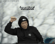 a man in a black hoodie with the word vacation written on it