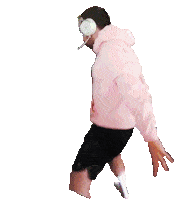 a man wearing headphones and a pink hoodie is walking