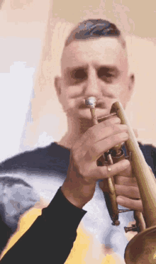 a man is playing a trumpet with a blurred background