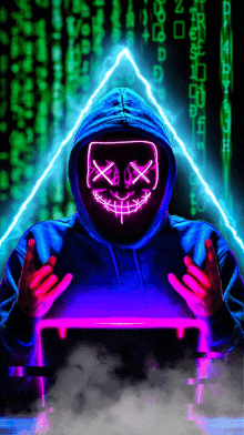 a man in a hoodie with a neon mask on his face is holding a laptop