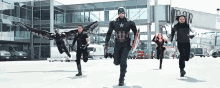 a group of captain america , falcon , winter soldier and scarlet witch are running on a runway .