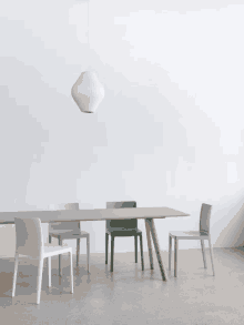 a table and chairs in a room with a pendant light