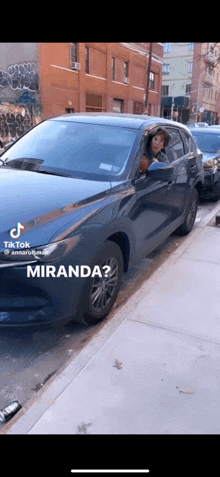 a woman in a hat is driving a car with the word miranda at the bottom