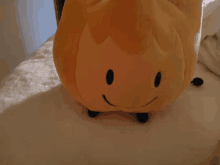 a stuffed animal that looks like a flame with a smile on its face