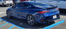 a blue infiniti q60 coupe is parked in a parking lot .