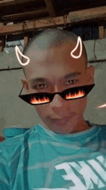 a man with a shaved head wearing sunglasses with fire on them .