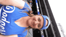 a woman wearing a dodgers shirt and hat smiles at the camera