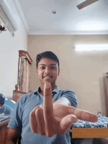 a young man is giving the middle finger to the camera in a room .