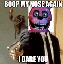 a man in a suit and tie is pointing a gun at a pink teddy bear mask .