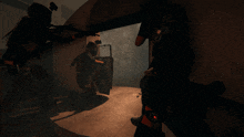 a man in a gas mask stands in a dark room with two other men