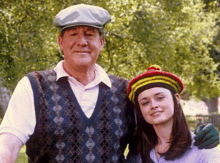 a man and a woman are standing next to each other in a park .