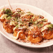 a plate of food with sauce , mayonnaise , and seaweed on a table .