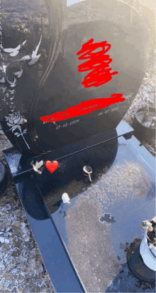 a heart shaped gravestone with the date 17-12-1979 written in red