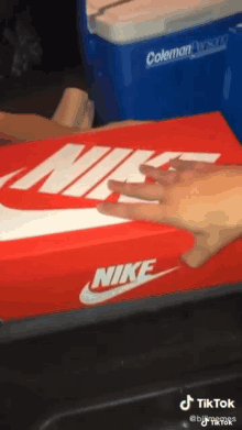 a person is holding a red nike box in their hand