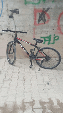 a fuji bike is parked in front of a wall with graffiti on it