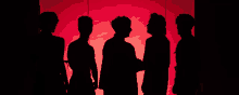 a group of people standing in front of a red backdrop