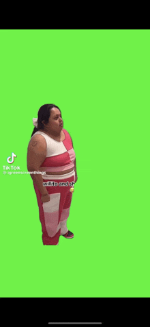 a woman in a pink and white striped outfit is standing in front of a green screen .