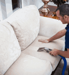 a man is using a vacuum cleaner to clean a couch