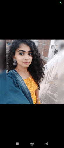 a young woman with curly hair is taking a selfie