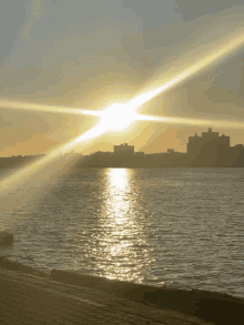 a sunset over a body of water with a city in the background