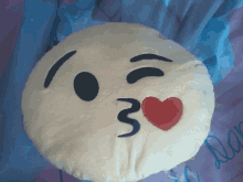 a pillow with a smiley face with a heart and the number 3 on it