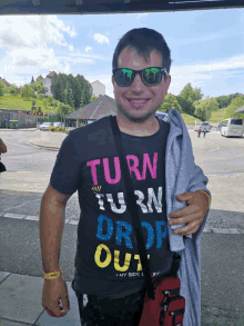 a man wearing sunglasses and a t-shirt that says turn turn drop out