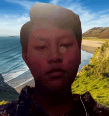 a man 's face is blurred in front of a beach and mountains